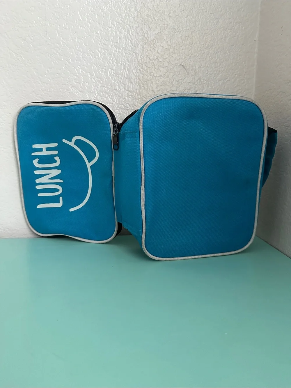 Walmart blue insulated lunch box with a minimalist white ’LUNCH’ graphic-used